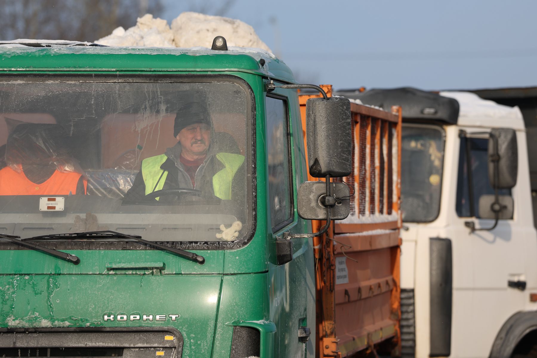 Машины везут снег