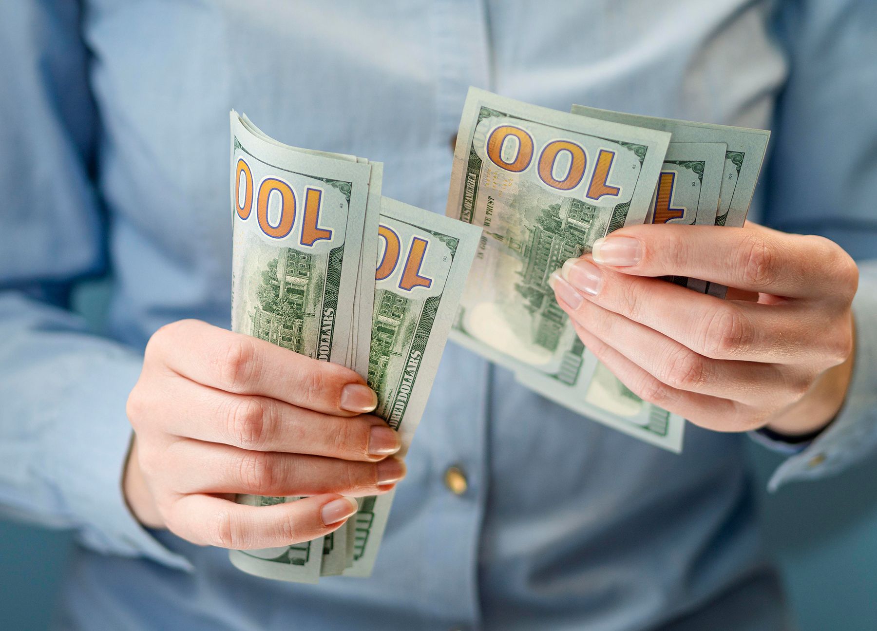 Девушка держит в руках доллары